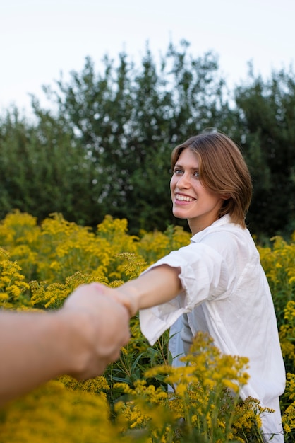 Vista lateral mujer sonriente sosteniendo la mano de su pareja