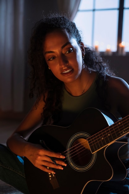 Foto gratuita vista lateral mujer sonriente tocando la guitarra