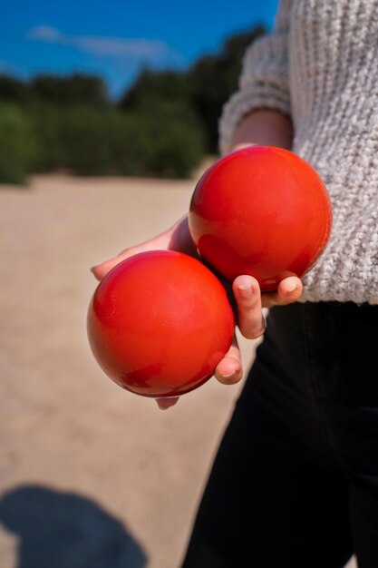 Vista lateral mujer sosteniendo bolas rojas