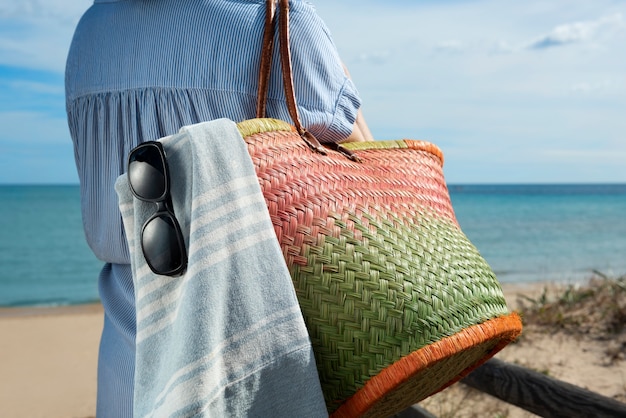 Foto gratuita vista lateral mujer sosteniendo bolsa de playa