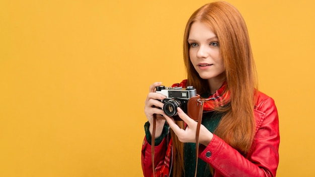 Foto gratuita vista lateral mujer sosteniendo la cámara