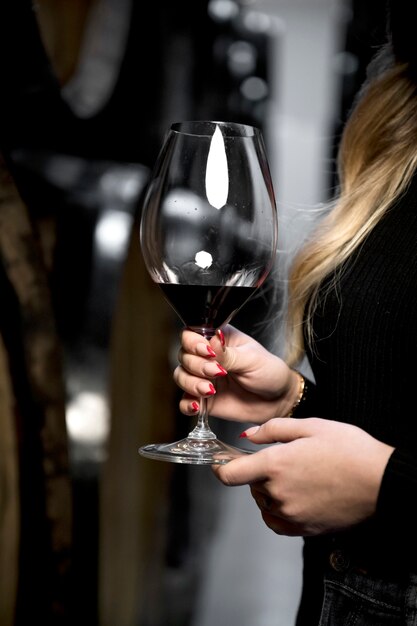 Vista lateral mujer sosteniendo copa de vino