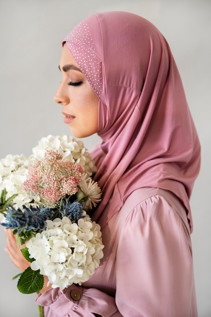 Vista lateral mujer sosteniendo flores