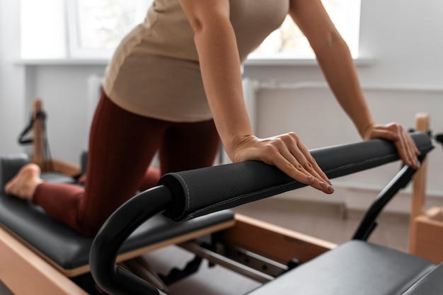 Foto gratuita vista lateral mujer tomando clase de reformador de pilates