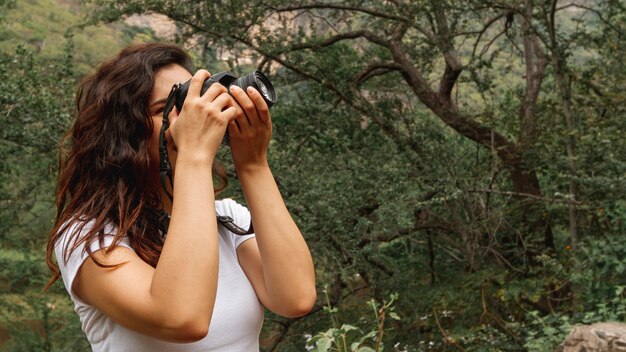 Vista lateral mujer tomando fotos de la naturaleza