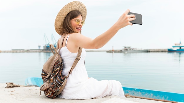 Vista lateral mujer tomando selfie