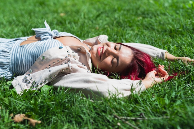 Vista lateral de la mujer tumbada en la hierba