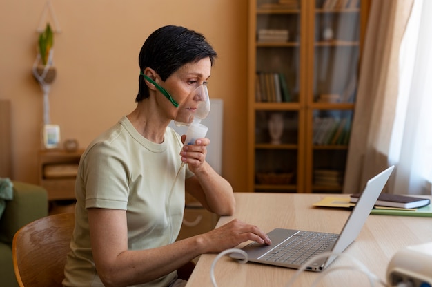 Foto gratuita vista lateral mujer usando nebulizador