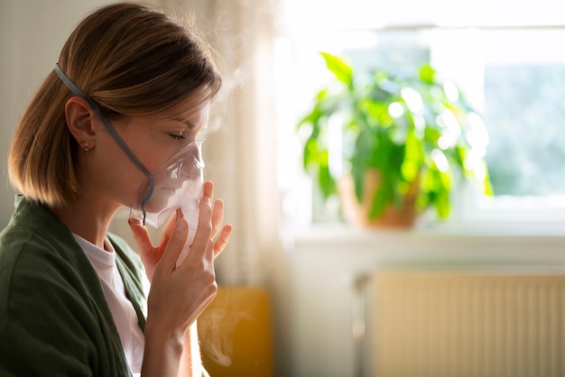 Vista lateral mujer usando nebulizador