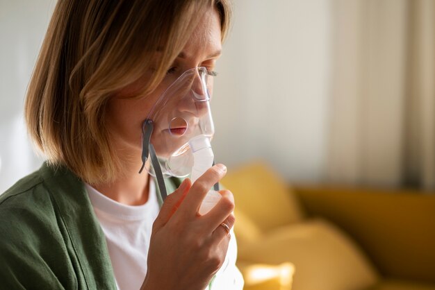 Vista lateral mujer usando nebulizador