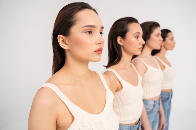 Foto gratuita vista lateral de mujeres en camisetas sin mangas y jeans posando en retratos minimalistas