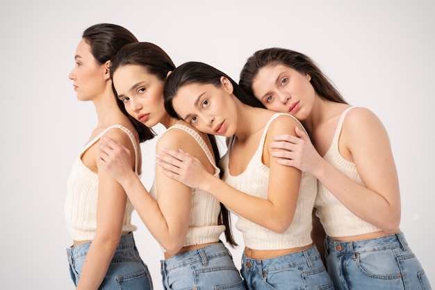 Vista lateral de mujeres en camisetas sin mangas y jeans posando en retratos minimalistas