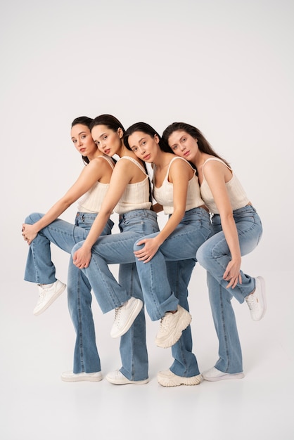 Vista lateral de mujeres en camisetas sin mangas y jeans posando en retratos minimalistas