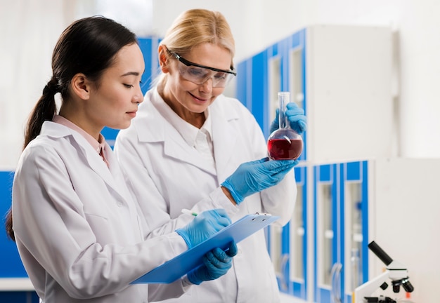 Vista lateral de mujeres científicas analizando sustancia en el laboratorio