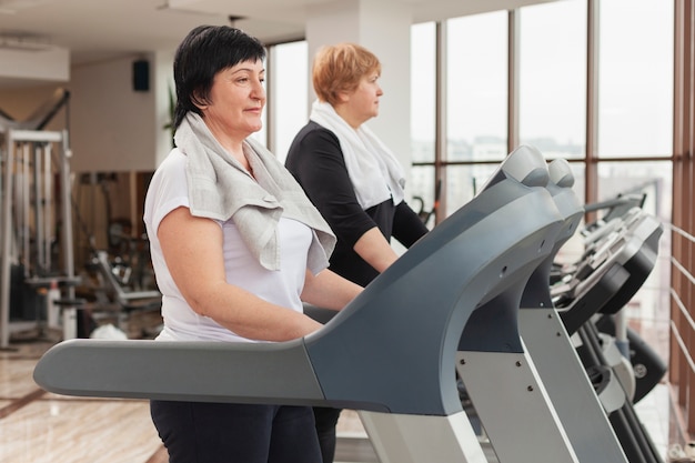 Foto gratuita vista lateral de mujeres en cinta de correr