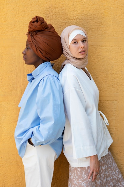 Vista lateral de mujeres con hijab posando juntas