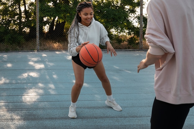 Foto gratuita vista lateral mujeres jugando baloncesto