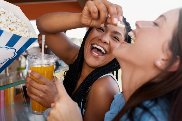 Vista lateral de mujeres sonrientes con bebidas