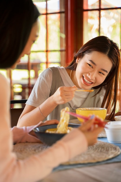 Vista lateral de mujeres sonrientes con comida deliciosa