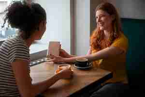 Foto gratuita vista lateral mujeres tomando café