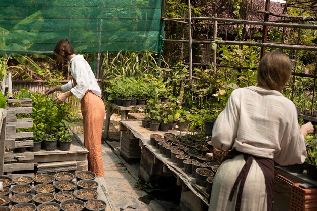 Vista lateral de mujeres trabajando con plantas.