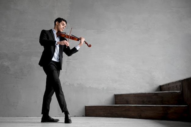 Foto gratuita vista lateral del músico masculino tocando el violín