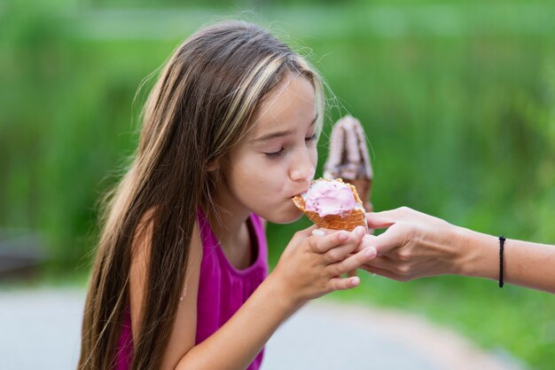 Vista lateral de la niña comiendo helado