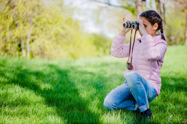 Foto gratuita vista lateral de niña concentrada con prismáticos