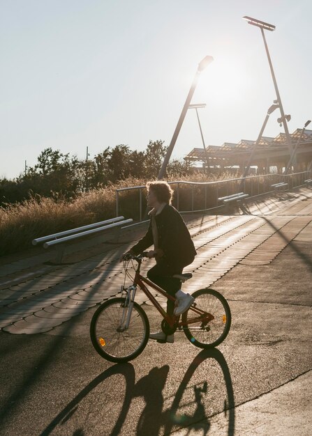 Vista lateral del niño en bicicleta afuera divirtiéndose