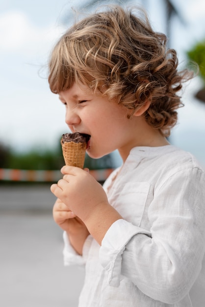 Vista lateral niño comiendo helado