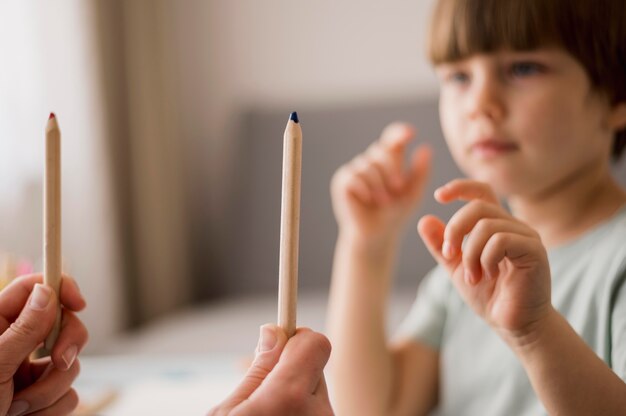 Vista lateral del niño desenfocado que recibe tutoría en casa