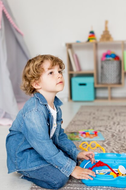 Foto gratuita vista lateral del niño jugando con juguetes en casa