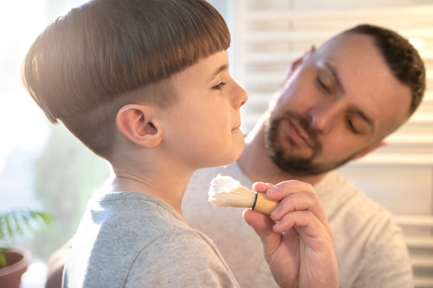 Foto gratuita vista lateral niño pequeño aprendiendo a afeitarse