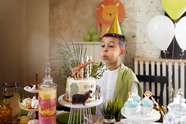 Foto gratuita vista lateral niño soplando velas