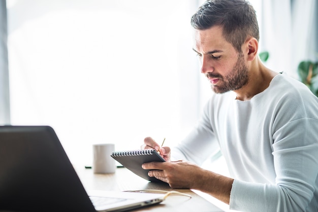 Foto gratuita vista lateral de una nota de escritura de empresario en diario