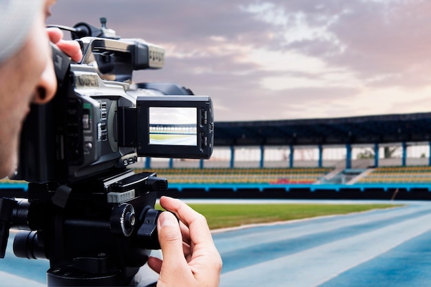 Vista lateral de noticias deportivas con hombre grabando