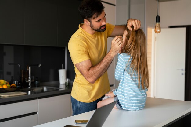 Vista lateral padre ayudando a hija con piojos