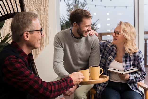 Foto gratuita vista lateral del padre dando a la madre y al hijo una taza caliente