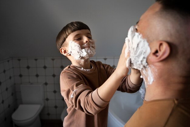 Foto gratuita vista lateral padre e hijo con crema de afeitar