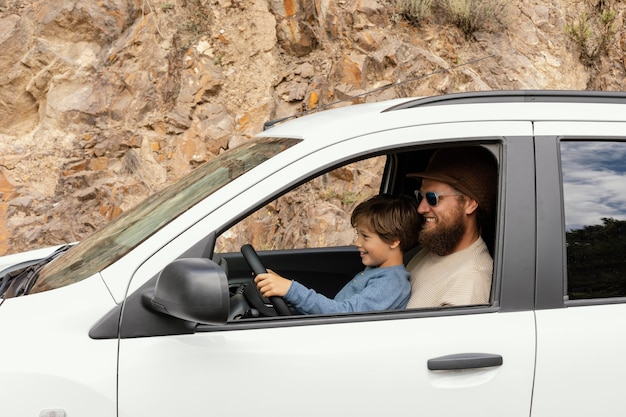 Vista lateral del padre con el hijo en la conducción de vuelta