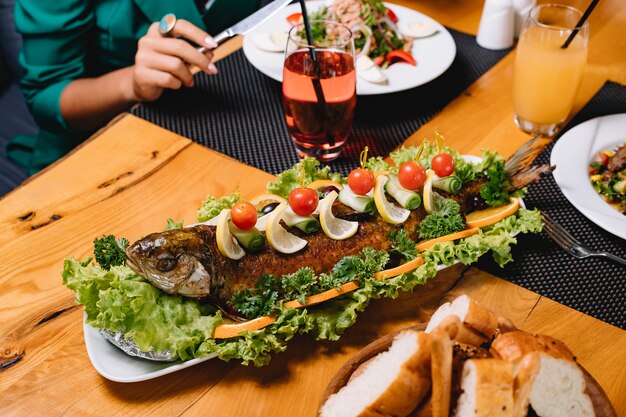 Vista lateral de pan de tomate y limón con lechuga de pescado a la parrilla