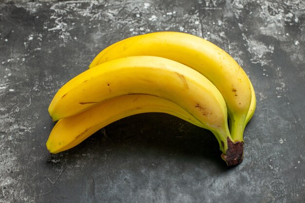 Vista lateral del paquete de bananas frescas de fuente de nutrición orgánica sobre fondo oscuro