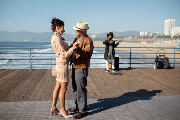 Vista lateral de la pareja de ancianos bailando en el compañero mientras está en una cita