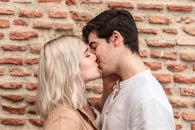 Vista lateral de la pareja besándose