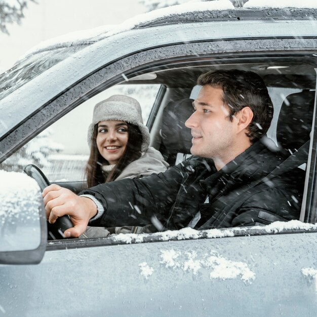 Vista lateral de la pareja juntos en el coche durante un viaje por carretera