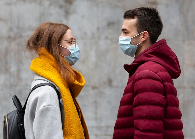 Foto gratuita vista lateral de la pareja con máscaras médicas