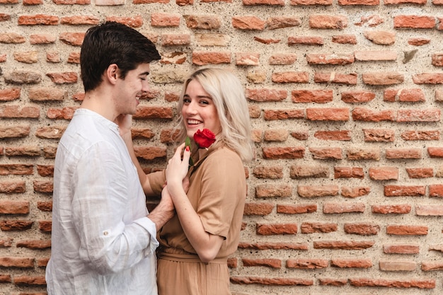 Foto gratuita vista lateral de la pareja posando con rose y copia espacio