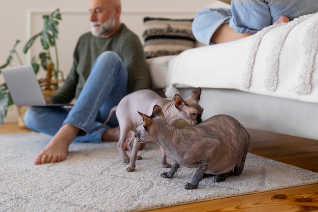 Foto gratuita vista lateral pareja senior con gato en casa