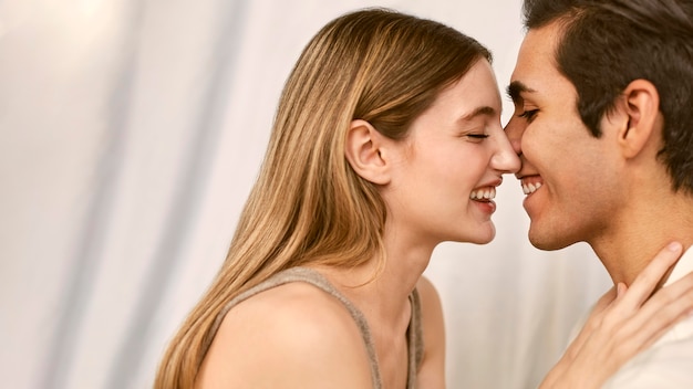 Foto gratuita vista lateral de la pareja sonriente abrazado con espacio de copia