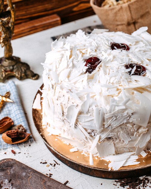 Vista lateral del pastel decorado con trozos de chocolate blanco sobre la mesa